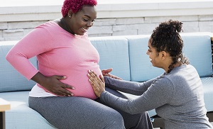 Stock image of pregnant person and doula
