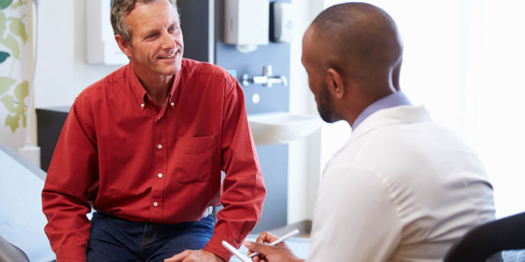gastroenterologist talking to man about colonoscopy