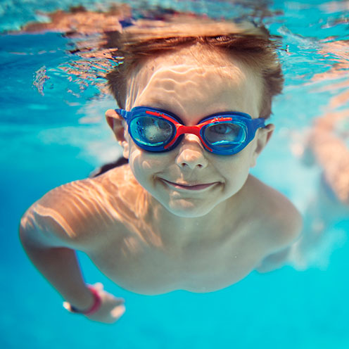 Child swimming underwater with goggles