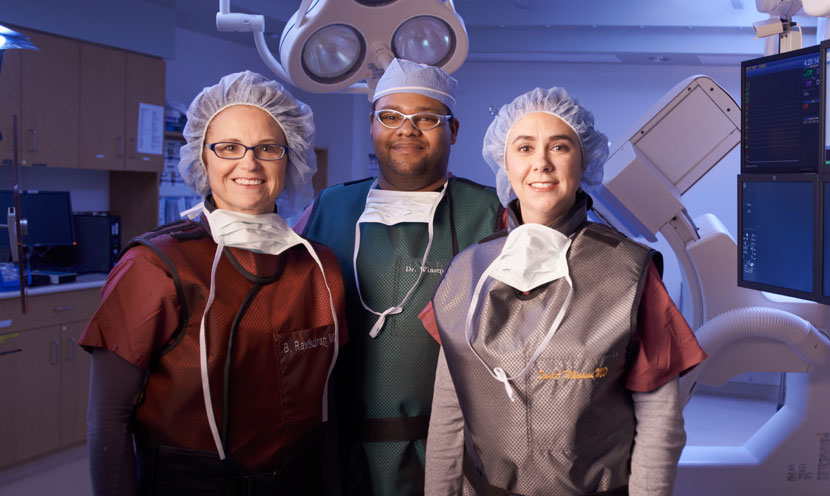 people smiling in heart catheterization lab