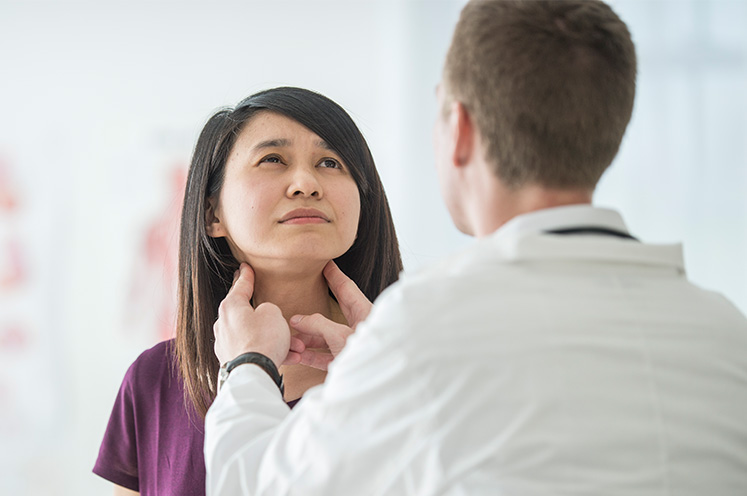 doctor examining patients thyroid
