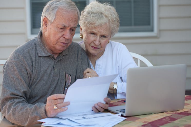 elderly couple looking at laptop