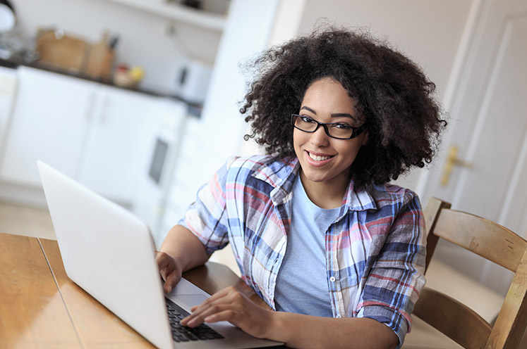 young woman in glasses working on her laptop