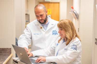 two physicians working on a laptop