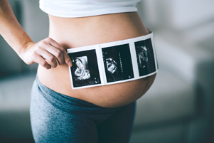 pregnant mom with ultrasound strip over tummy