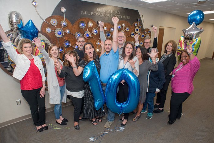 group celebrating lives of 10 year glioblastoma survivors with balloons shaped like number 10