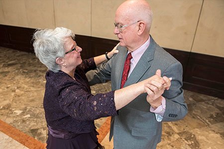 Breast Cancer patient Lillian and her husband looking at each other while ballroom dancing