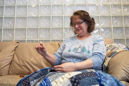 head and neck cancer patient bobbie knitting a quilt