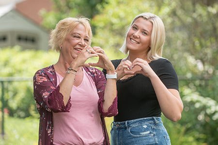 mother and daugher forming heart shape with hands