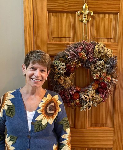 mary alice standing in front of fall wreath