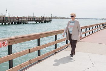 Spine patient Beverly walking by the detroit river