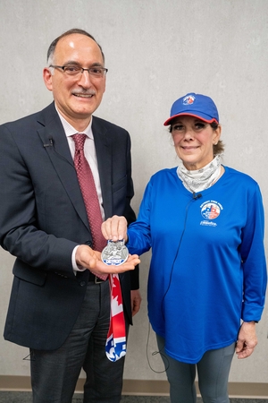 Brenda spine patient and doctor with medal