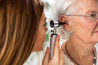 doctor looking in the ear of female patient
