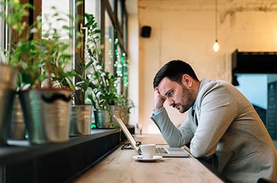 man looking thoughtfully at computer
