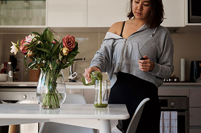 woman pouring green juice