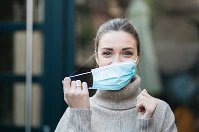woman taking off mask