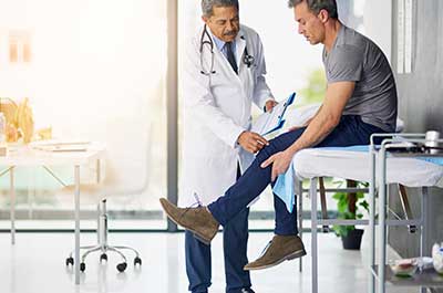doctor examining patients knee