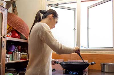woman cooking with wok