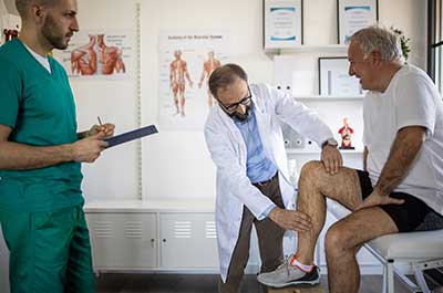 doctor examining patients knee