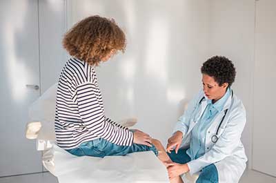 doctor examining patients knee
