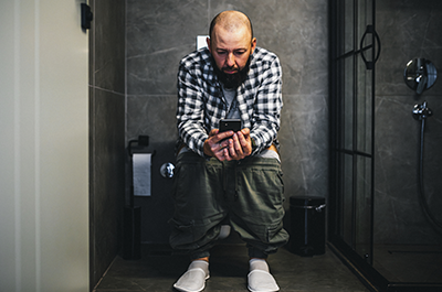 man sitting on toilet