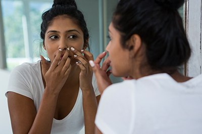 woman popping pimple