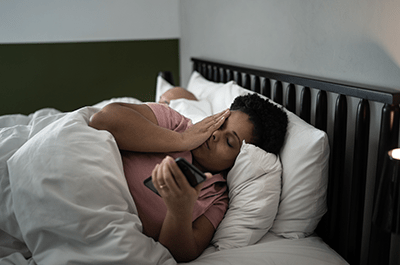 woman texting in bed