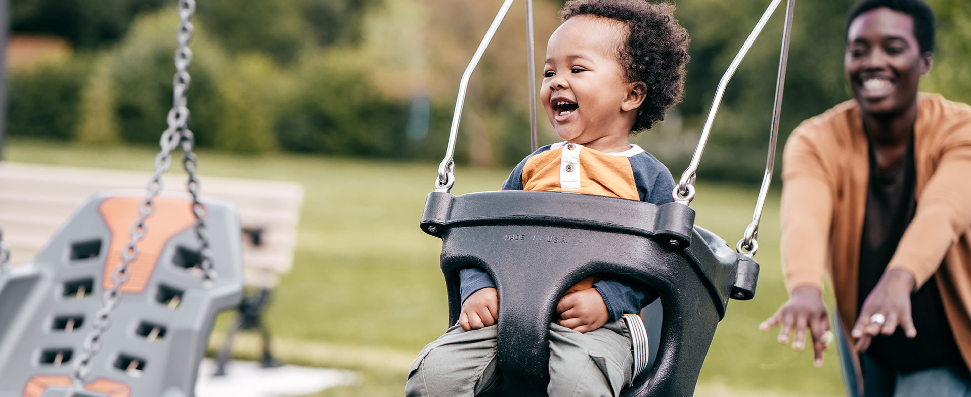 mother pushing child on swings