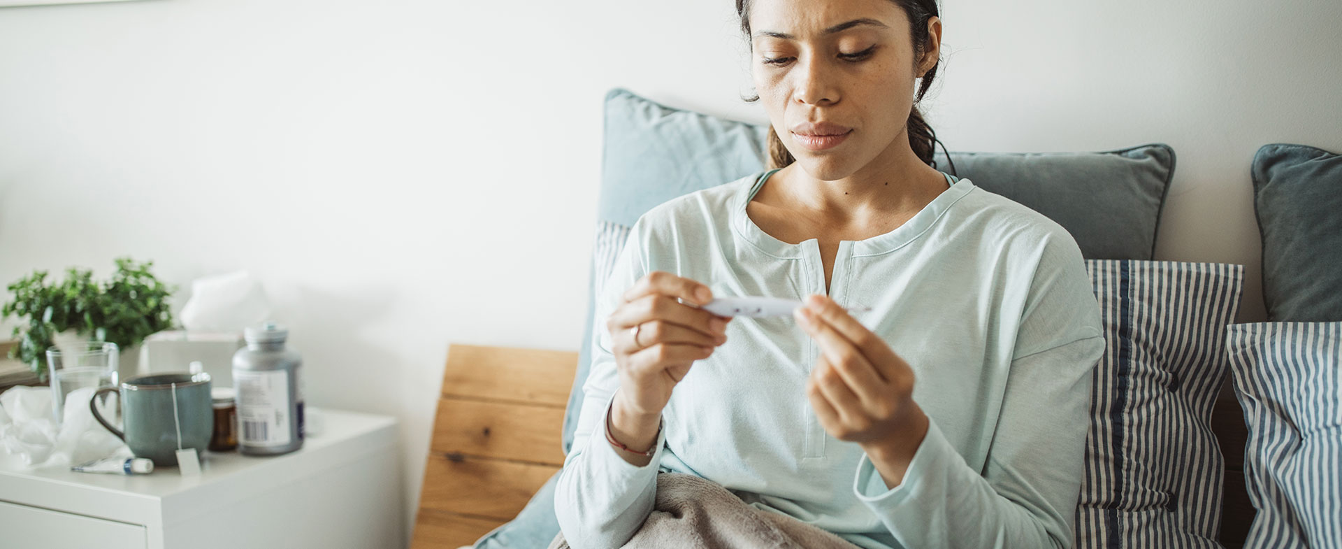 woman taking temperature in bed