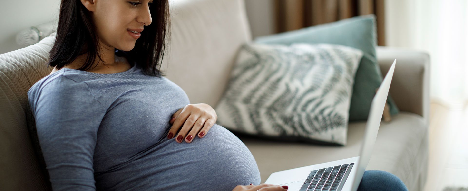 pregnant woman reading on laptop