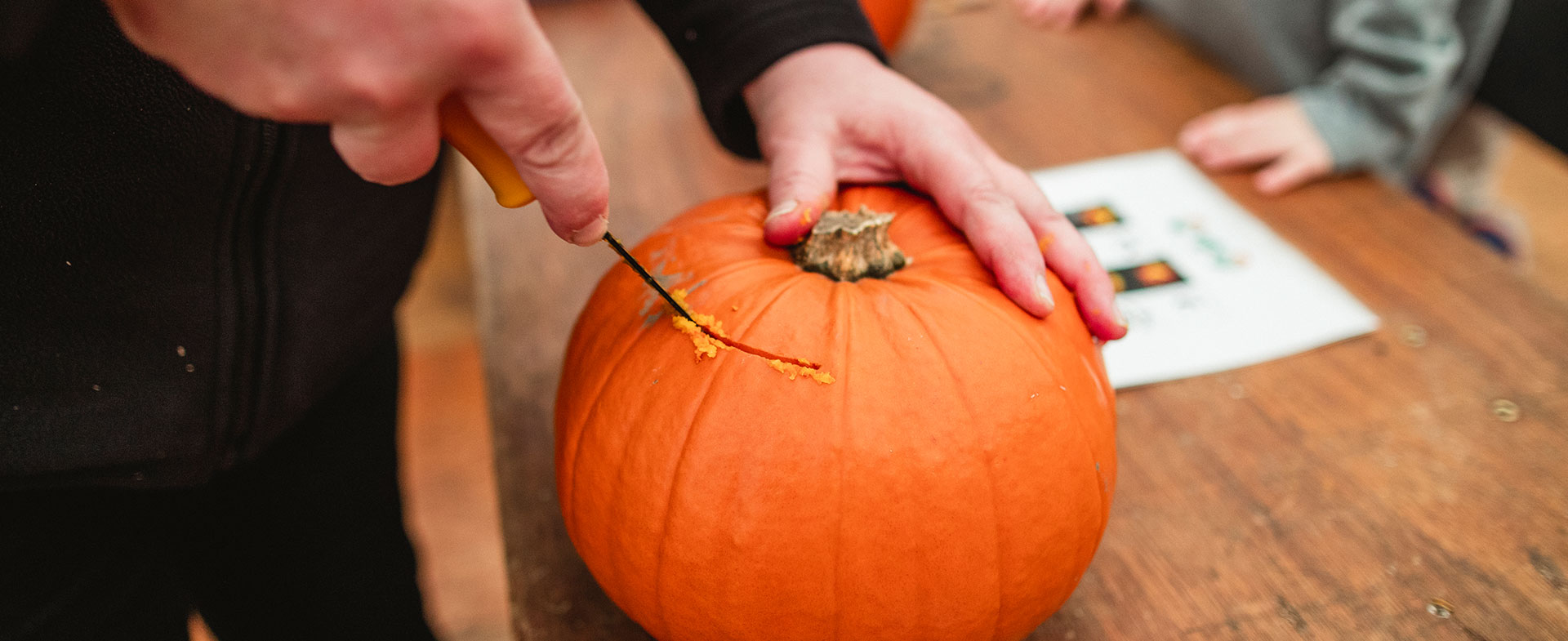 man carving pumpkin