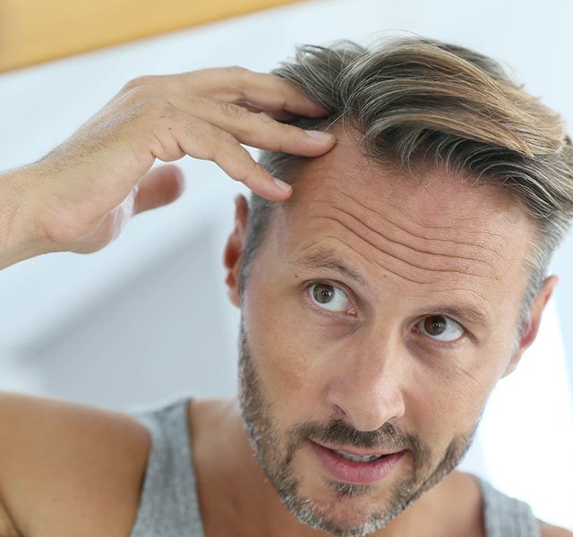 man looking at his hair