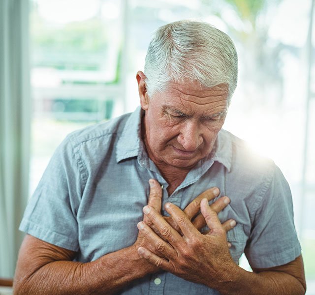 older man holding his chest
