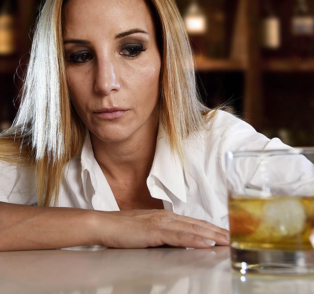 woman looking at her drink