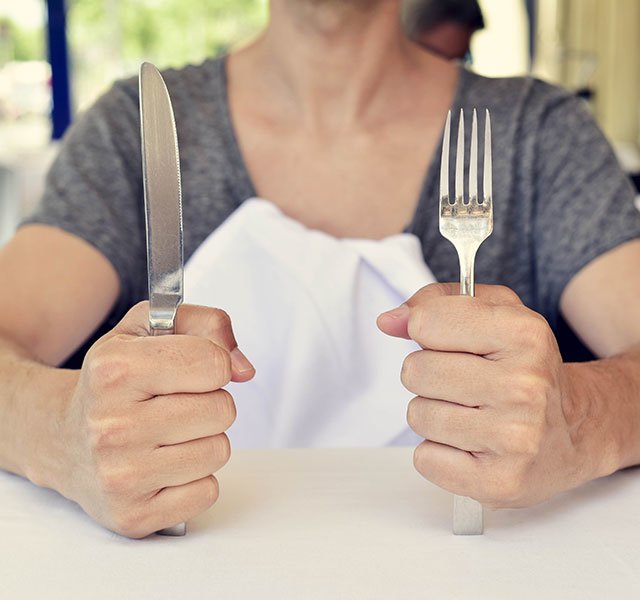 woman holding a knife and fork