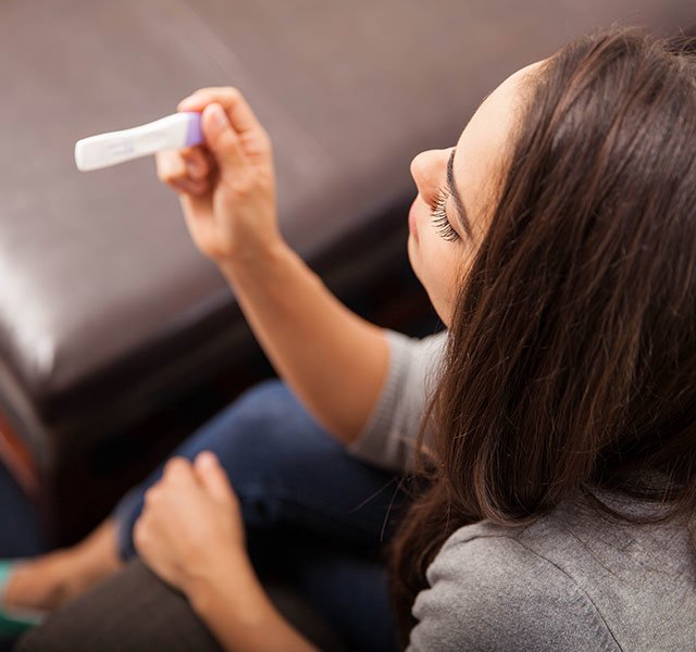 woman looking at pregnancy test
