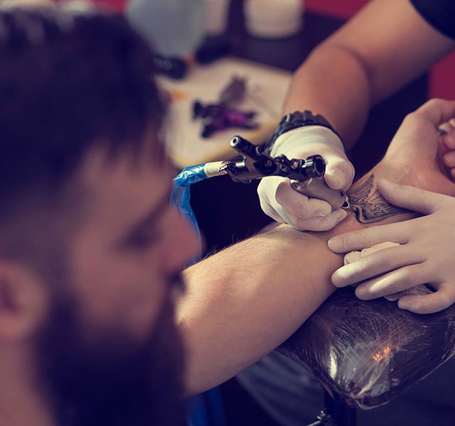 man getting a wrist tattoo