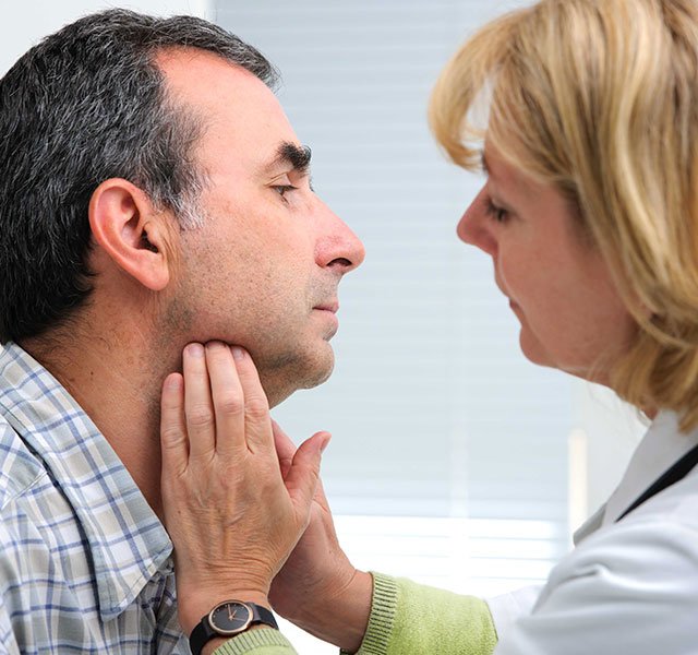 doctor examining the neck of a patient
