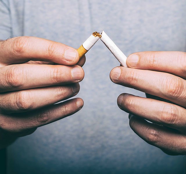 man holding broken cigarette