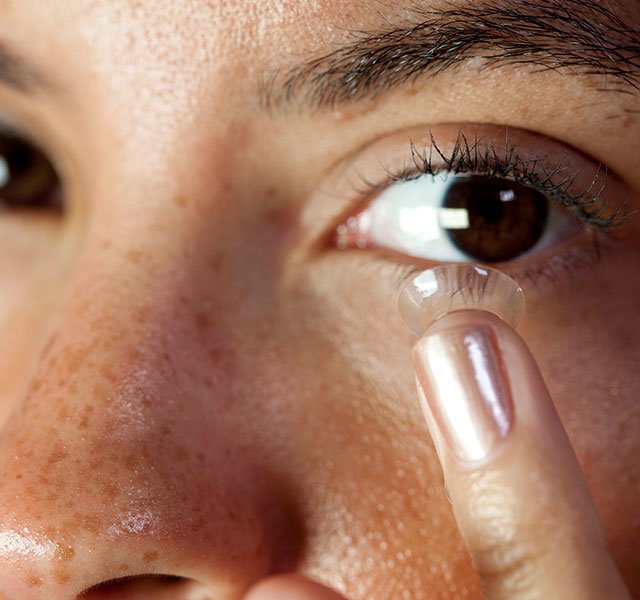 woman putting in a contact lense