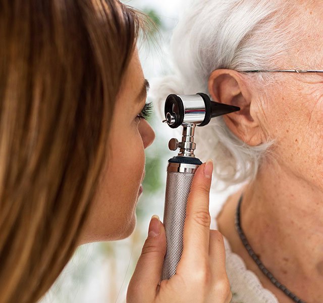 doctor looking in the ear of female patient