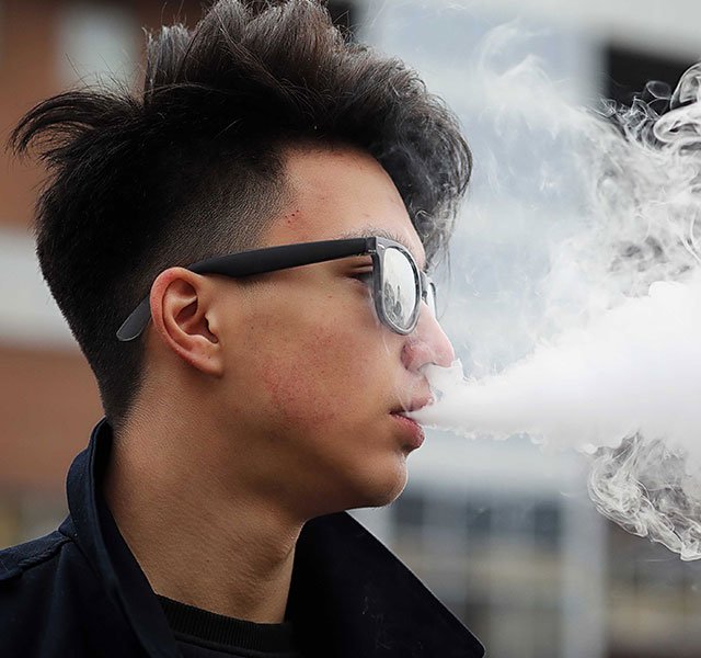 man blowing out smoke