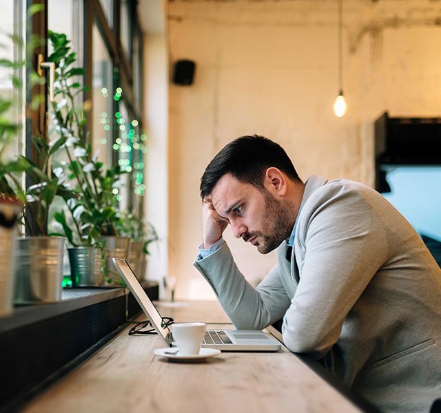 man looking thoughtfully at computer