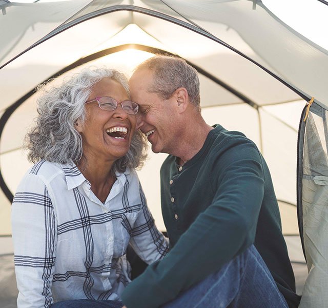 man and woman laughing in a tent