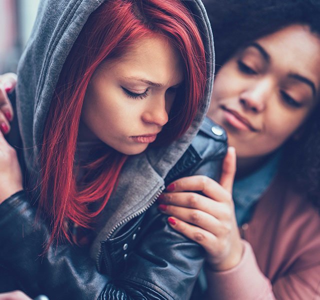 younger woman being comforted by older woman