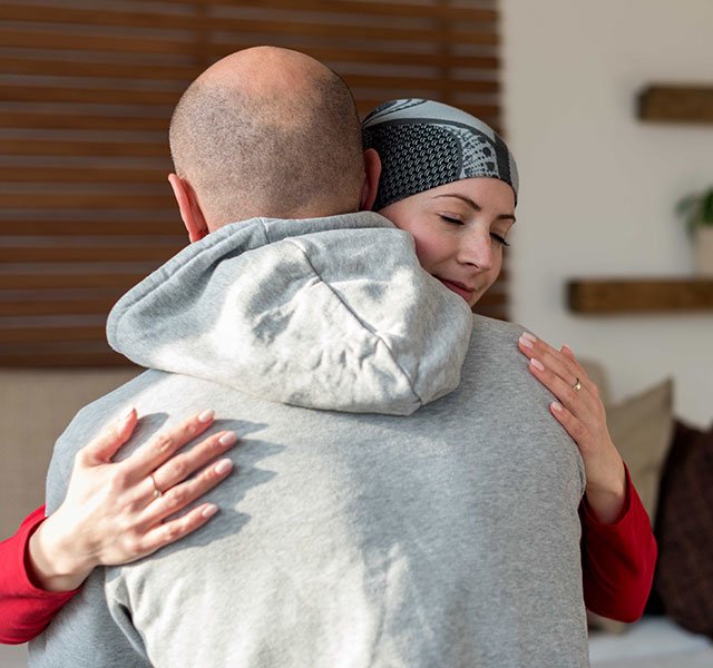 man hugging woman with head scarf