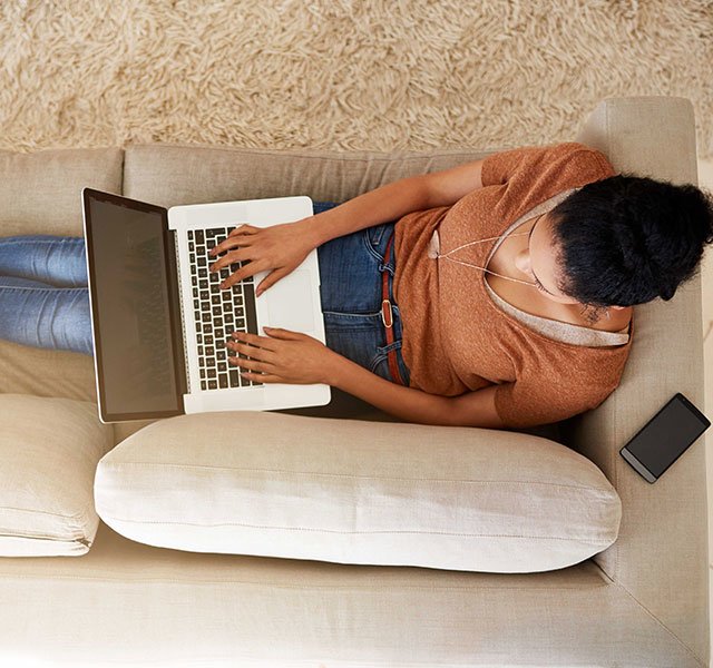woman on couch with computer