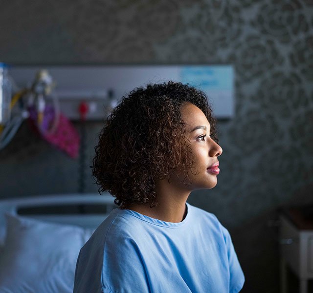 young woman in medical gown sitting