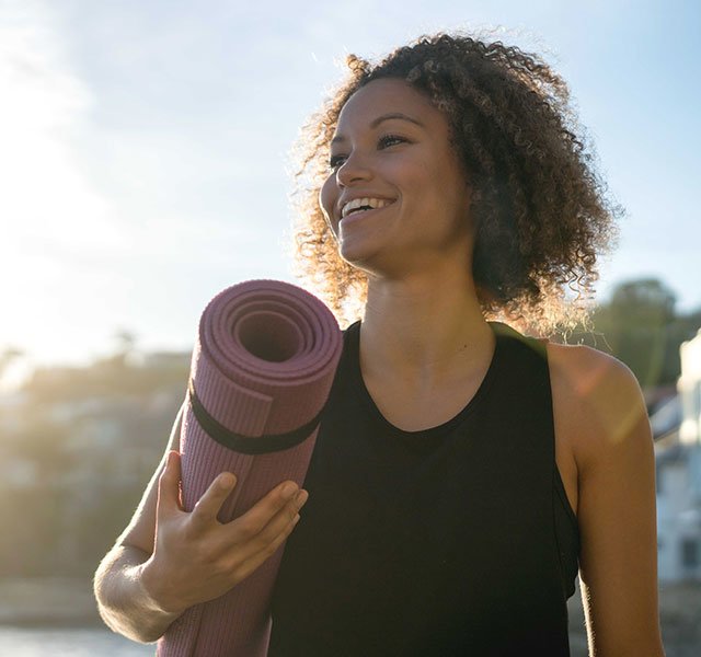 woman holding a yoga mat