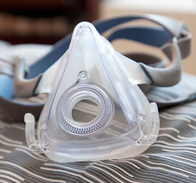 CPAP mask sitting on a bed